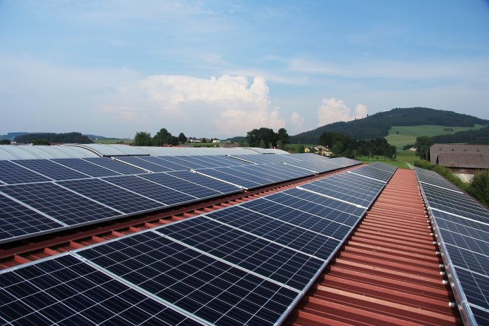 solar-power-862602_1280 painéis solares em cima de um telhado com um grande céu limpo acima