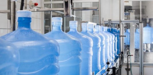 vasilhames de 20 litros dispostos em linha numa indústria