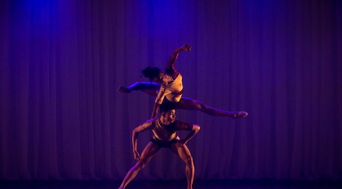 homem e mulher em um palco dançam um sobre o outro