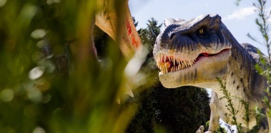 Continente Shopping abre exposição “Mundo Jurássico” neste fim de semana reproduçaõ realista de um dinossauro carnívoro no meio da vegetação