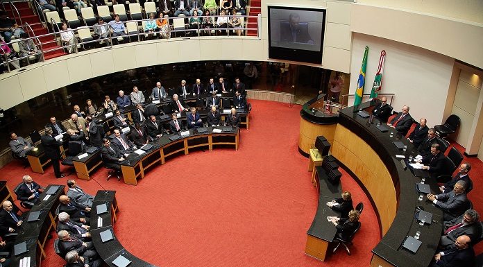 plenário da assembleia visto de cima com bancadas circulares e pessoas sentadas em sessão