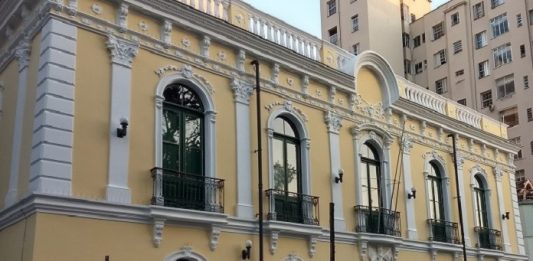 fachada do prédio histórico renovada com as cores originais em amarelo claro e branco em volta das janelas