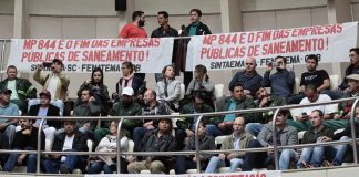 público diverso sentado em auditório superior da alesc com faixas contra a privatização e a mp