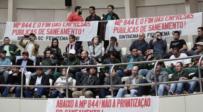 público diverso sentado em auditório superior da alesc com faixas contra a privatização e a mp