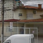 fachada da casa sede do igp em são josé; portão de grade e um poste na frente com muitos fios; alguns carros estacionados