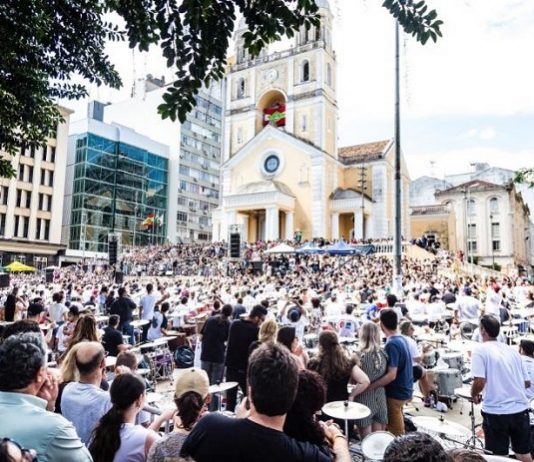 Edição 2018 da orquestra de baterias de Florianópolis ocorre neste domingo (19) grande público em uma praã em frente a uma catedral assiste os vários bateristas
