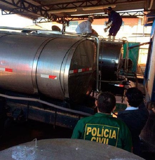 agentes da polícia civil examinam caminhões-tanque de leite estacionados