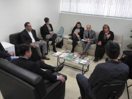 Udesc terá escritório de intercâmbio nos EUA grupo de homens e mulheres em reunião em uma sala com sofás e poltronas em volta de uma pequena mesa de centro ao lado de uma janela