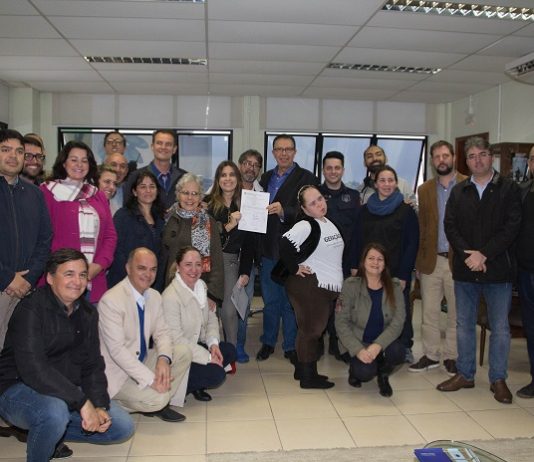 grande grupo de pessoas, entre homens e mulheres, posa para foto; a maioria sorri