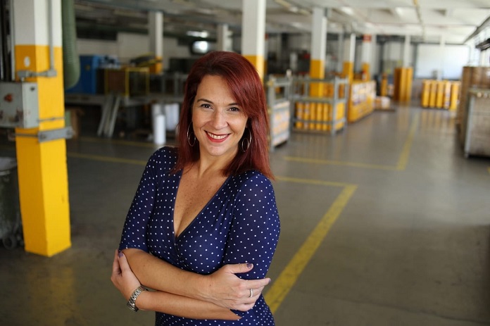 foto de ana maria, sorridente para a câmera em uma grande garagem