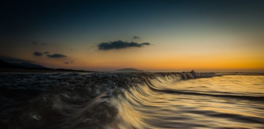 fotografia do mar em movimento com por do sol de guel varalla