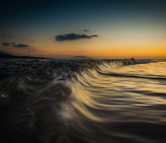 fotografia do mar em movimento com por do sol de guel varalla
