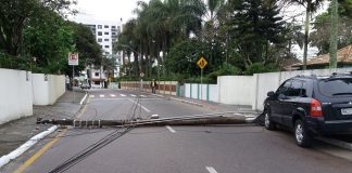 poste caído atravessado na rua, com carro suv em cima da calçada e fios espalhados