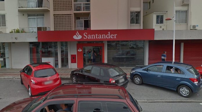 fachada da agência do santander com alguns carros parados na frente