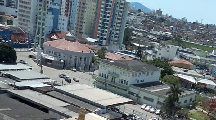 foto tirada de cima de um prédio mostra ambulâncias e pessoas aglomeradas em frente ao restaurante e demais casas em volta, na parte de cima, prédios e casas mais longe