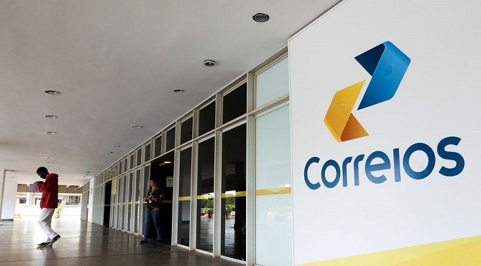 fachada externa de uma agência dos correios cuja porta de entrada fica em uma galeria