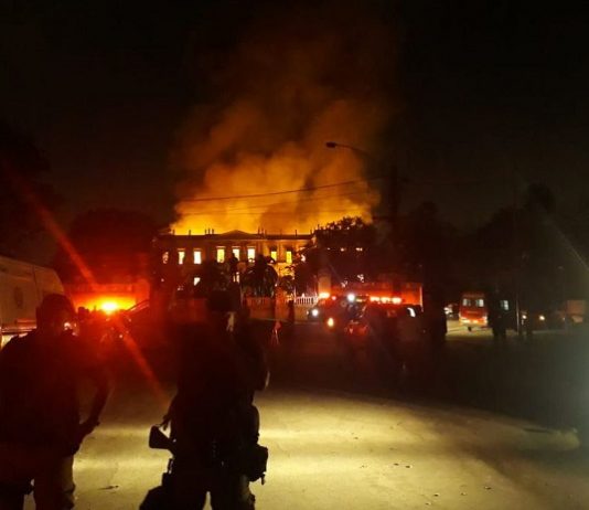 Saiba o que guardava o bicentenário Museu Nacional, incendiado neste domingo foto noturna da fachada do prédio histórico em chamas; algumas silhuetas de agentes de segurança na frente