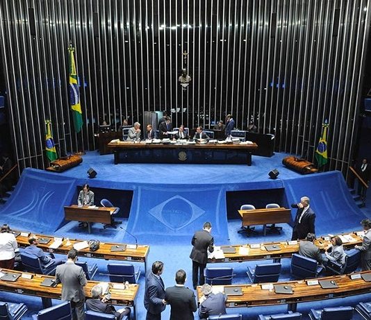 salão do senado visto de cima mostrando à mesa diretora ao centro e bancadas na parte de baixo da foto, com pessoas espalhadas