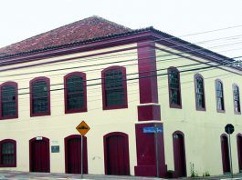 fachada do prédio de arquitetura portuguesa; alguns fios de energia passam na frente