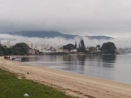 Primavera terá temperaturas acima da média no Estado praia com mar calmo e enseada ao fundo com nevoeiro sobre o continente