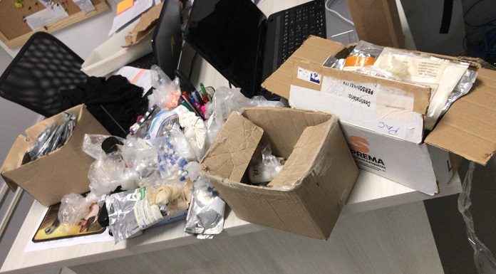 diversas caixas de papelão e embalagens abertas sobre uma mesa de escritório; tudo bagunçado
