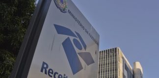 fachada externa de prédio da receita federal com o logo e inscrição em placa