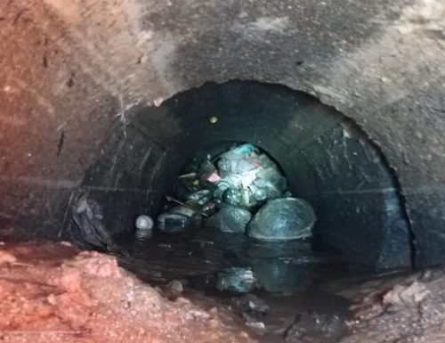 foto de um monte de lixo entupido dentro de uma tubulação de esgoto