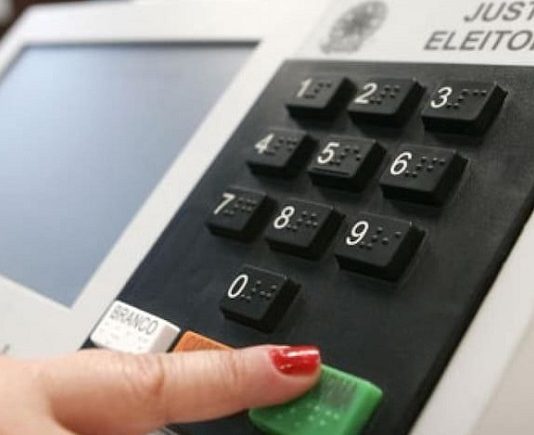 TSE aguarda deliberação do Congresso Nacional sobre data das eleições mão feminina aperta a tecla confirma da urna eeletrônica