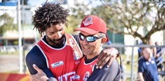 os dois homens com o uniforme de são jose se abraçam em comemoração