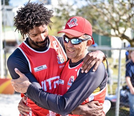 os dois homens com o uniforme de são jose se abraçam em comemoração