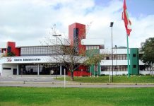 fodo do prédio sede do governo, com gramados e árvores na frente e a bandeira de sc