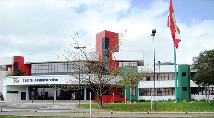 fodo do prédio sede do governo, com gramados e árvores na frente e a bandeira de sc