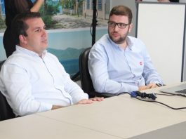prefeito camilo fala sentado em frente a uma mesa, ao lado de outro homem de óculos que o observa
