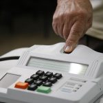 pessoa coloca o dedo para ser lido por leitor biométrico de votação