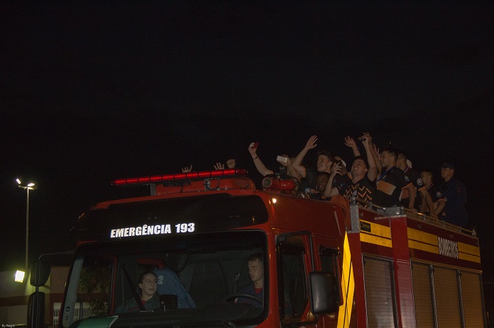 jogadores em cima do caminhao de bombeiros comemorando em foto noturna