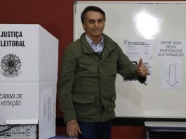 Jair Bolsonaro é eleito presidente do Brasil bolsonaro faz sinal de positivo ao lado de cabine eleitoral