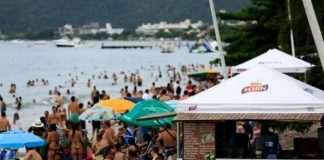 aglomeração de banhistas na areia da praia de canasvieiras ao lado de uma barraca de bebidas