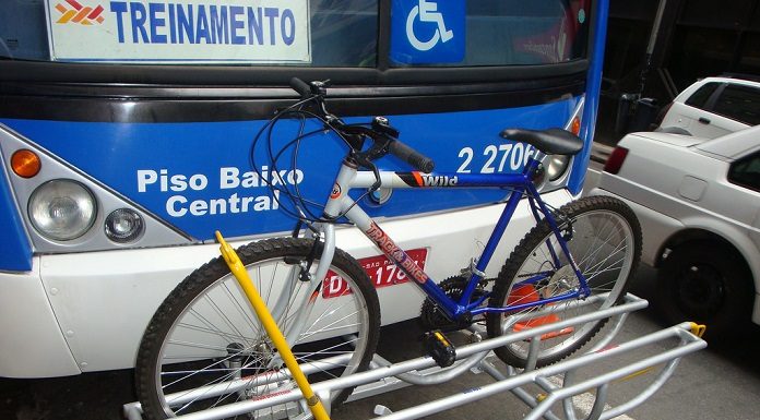 bicicleta encaixada em suporte à frente de um ônibus