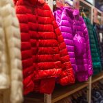 jaquetas coloridas infantis dispostas em mostrador de loja