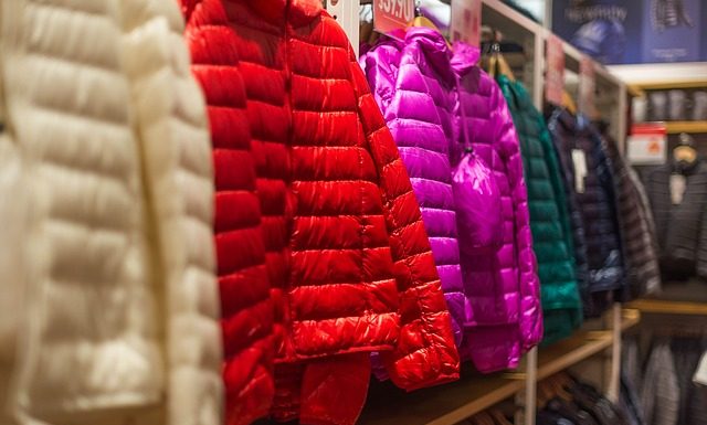 jaquetas coloridas infantis dispostas em mostrador de loja