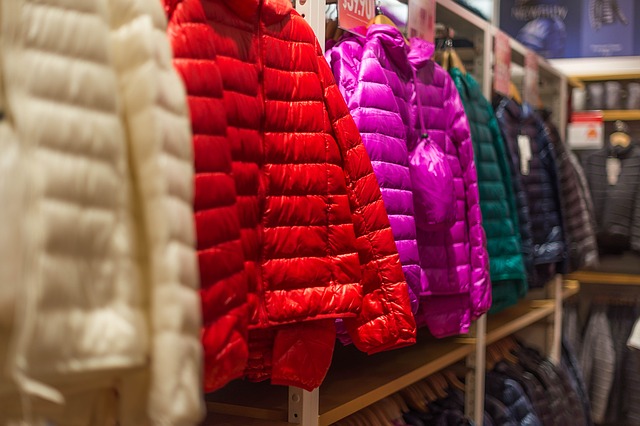 jaquetas coloridas infantis dispostas em mostrador de loja
