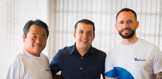 prefeito camilo posa para a foto com dois homens da empresa, usando camisas escritas "repasse"