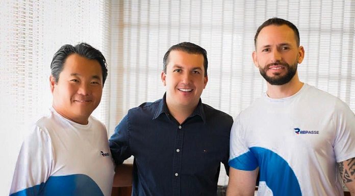 prefeito camilo posa para a foto com dois homens da empresa, usando camisas escritas "repasse"