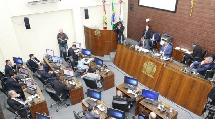 parlamento da câmara, onde vereadores estão sentados nas mesas, visto de cima em dia de sessão