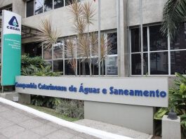 fachada da sede da casan, com placas e logos da companhia