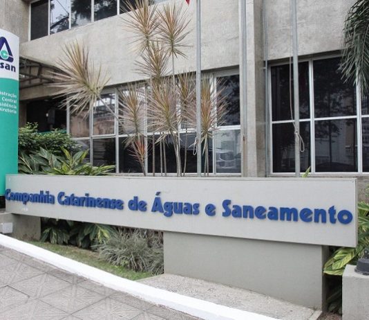 fachada da sede da casan, com placas e logos da companhia