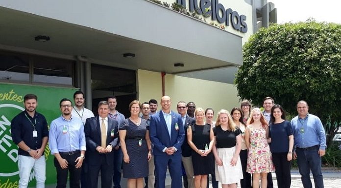 grupo da comitiva com membros da prefeitura, incluindo a prefeita adeliana, posa para foto em frente à intelbras