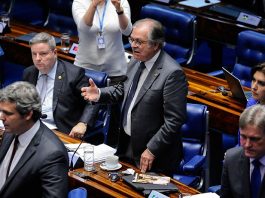 senador fala em pé ao microfone visto de cima entre outros senadores sentados nas bancadas