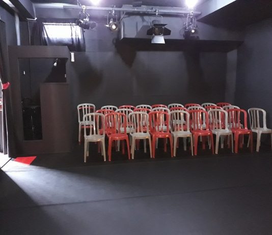 Estúdio de artes oferece novas possibilidades culturais cadeiras de plásticos dispostas para plateia dentro de uma sala totalmente preta para o teatro