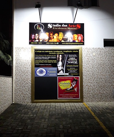 foto noturna da porta de entrada, com diversos cartazes de cursos oferecidos